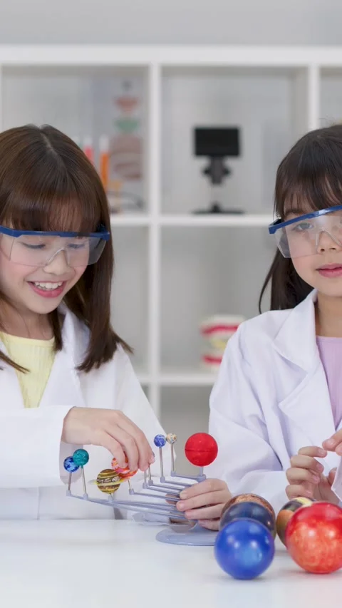 Elementary Students in Lab Coats Studying Solar System Model Stock Footage 341074106