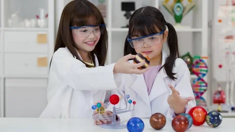 Elementary Students in Lab Coats Studying Solar System Model Stock Footage 341074203