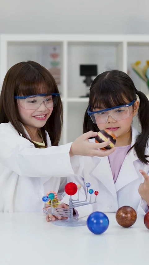 Elementary Students in Lab Coats Studying Solar System Model Stock Footage 341667729