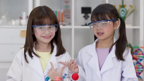 Elementary Students in Lab Coats Studying Solar System Model Stock Footage 341917353