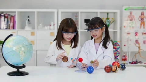 Elementary Students in Lab Coats Studying Solar System Model in Classroom Stock Footage 342313059