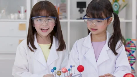 Elementary Students in Lab Coats Studying Solar System Model Stock Footage 342313089