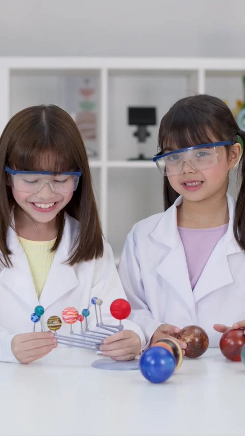 Elementary Students in Lab Coats Studying Solar System Model Stock Footage 342313201