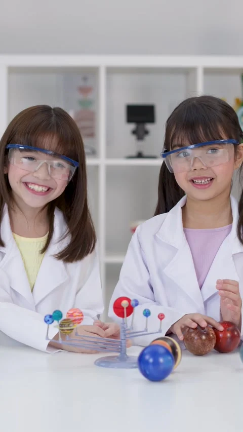 Elementary Students in Lab Coats Studying Solar System Model Stock Footage 345194945