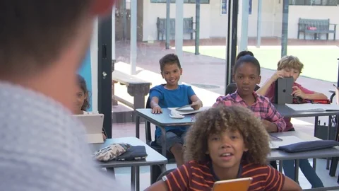 Elementary students looking to teacher, over shoulder view Stock Footage
