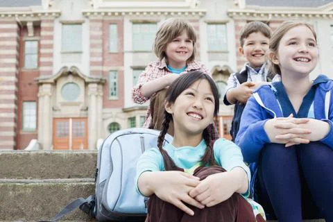 Elementary students outside of school building Stock Photos