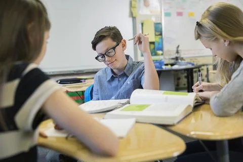 Elementary students studying at desks in classroom Stock Photos