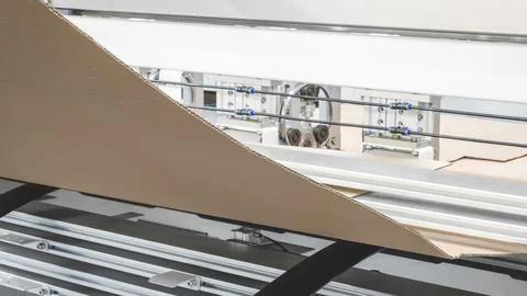Elements of cardboard boxes are collected in stack. Conveyor line for the pro Stock Photos