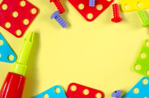 Elements of children's multi-colored constructor on a yellow background 스톡 사진