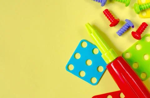 Elements of children's multi-colored constructor on a yellow background Stock Photos