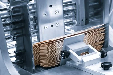 Elements of corton boxes are collected in stack. Conveyor line for the produc 库存照片