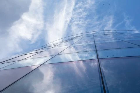 Elements of the glass facede skyscraper with reflecting sky and clouds Foto stock