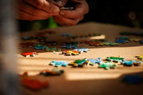 Elements of the puzzle are laid out on a table. Stock Photos