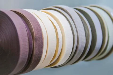 Elements of sewing, textile tapes, rubber bands, rolled up, pastel colors. Stock Photos