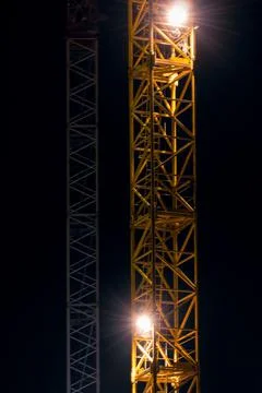 Elements of the tower of the construction high-rise yellow crane at night. Ba Stock Photos