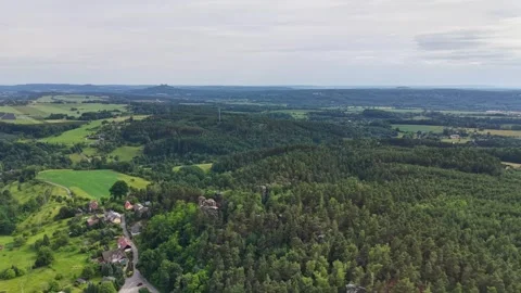 Elevated aerial panorama of patchwork fields and dense forest with rolling Stock Footage 346261743