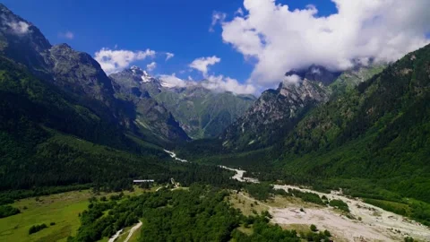 Elevated aerial view of lush green Becho Valley and Dolra River toward Greater Stock Footage 346797792
