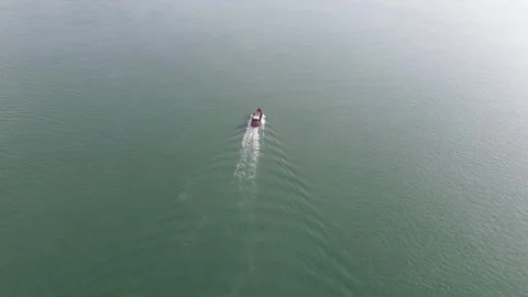 Elevated drone perspective captures a solitary boat gracefully navigating Stock-Footage 325191180