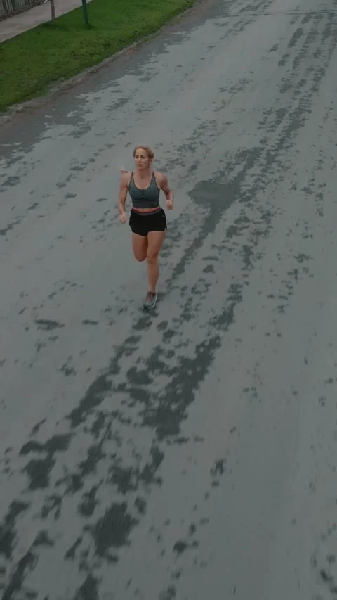 Elevated front view of female runner approaching along a road Stock Footage 340046900