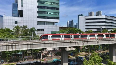 Elevated Light Rail Train Passing Through Modern Cityscape Stock Photos