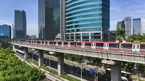 Elevated Light Rail Train Passing Through Modern Cityscape Stock Photos