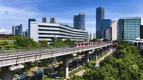 Elevated Light Rail Train Passing Through Modern Cityscape Stockfoto's