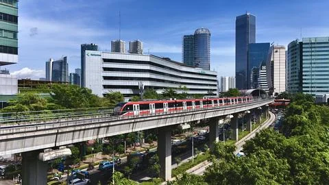 Elevated Light Rail Train Passing Through Modern Cityscape Stockfoto's