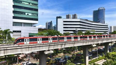 Elevated Light Rail Train Passing Through Modern Cityscape Stockfoto's