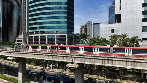 Elevated Light Rail Train Passing Through Modern Cityscape Stockfoto's