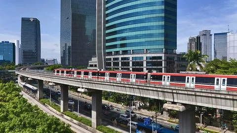 Elevated Light Rail Train Passing Through Modern Cityscape Stockfoto's