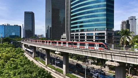 Elevated Light Rail Train Passing Through Modern Cityscape Stockfoto's