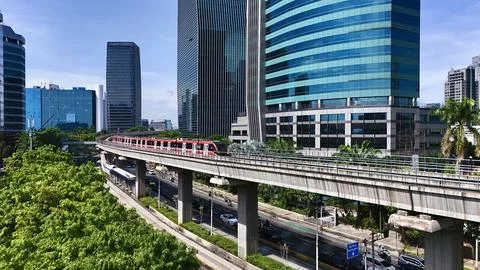 Elevated Light Rail Train Passing Through Modern Cityscape Stock Photos
