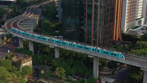 Elevated Metro Train Passing Modern City Buildings and Greenery 스톡 동영상 345714962