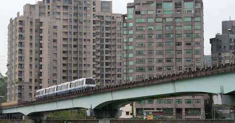 Elevated metro train traveling on overpass bridge against residential buildings Stockbeeldmateriaal 341100229