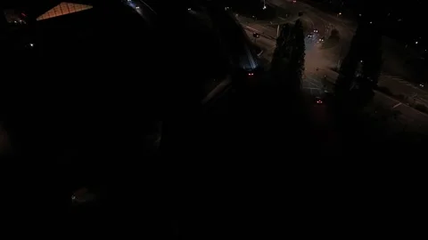 Elevated multi-lane road curves past illuminated intersection, scattered car Video stock 347701090