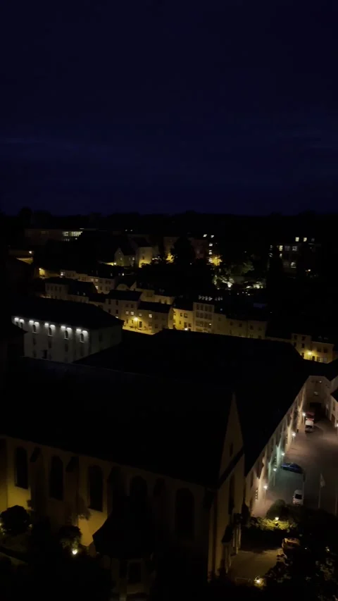 Elevated night time view of a charming old European town with glowing stree.. 스톡 동영상 346910976
