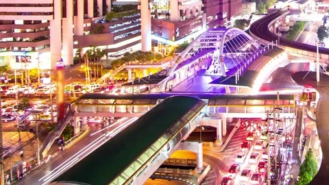 Elevated Night View of Modern Cityscape with Illuminated Pedestrian Bridge 動画素材 310216594
