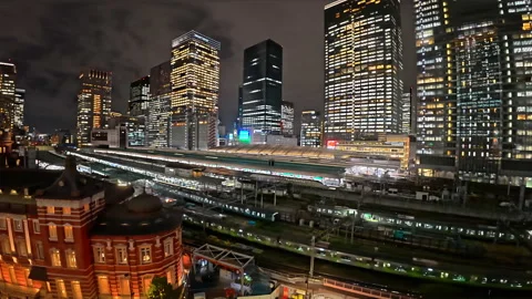 Elevated night view of tokyo station with trains moving on tracks Stock Footage 329838906