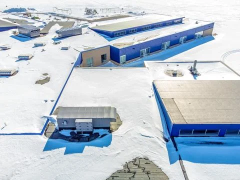 Elevated overhead drone view of a flat roofed building with snow load and Stock Photos