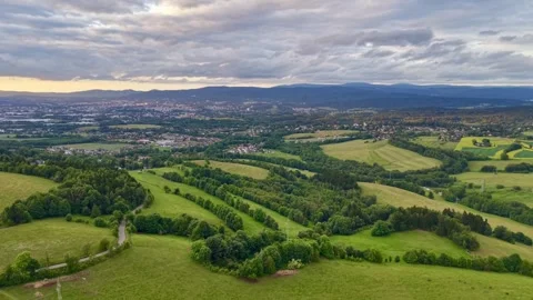 Elevated panoramic view of rolling green hills, patchwork farmland, winding Stock Footage 342359397