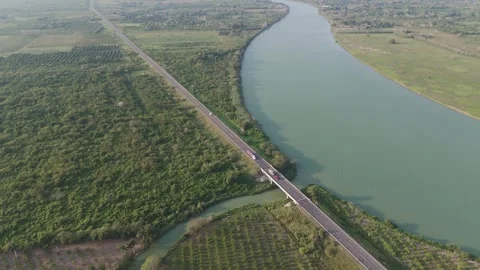 Elevated shot of a long straight road running through a lush green landscape Vídeo Stock 337912549