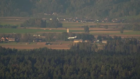 An elevated side view of a commuter airplane on its final approach Stock Footage 319382334