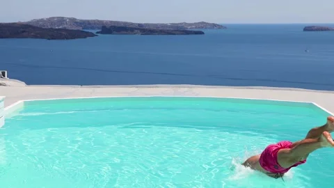 Elevated slow motion view of a man diving into the swimming pool Video stock 155630335