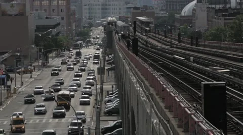 Elevated subway rolls into station with traffic below Stock Footage 40544576