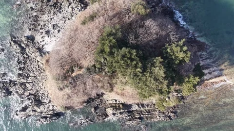 Elevated Top Down Ocean Waves Breaking over Rocky Shore, Aerial View Stock Footage 344778369