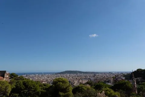 Elevated tourist viewpoint faces sprawling seaside city beneath clear blue .. 库存照片