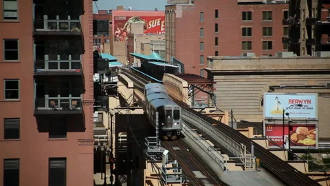 Elevated train in Chicago pulls out of a station amidst city, Illinois USA Stock Footage 202903919