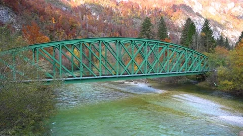 Elevated view of Alpine river flowing under iron railway bridge Stock Footage 143346691