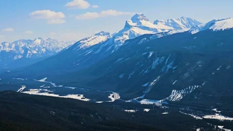 Elevated view of Banff, Canada reveals snowcovered peaks, evergreen forest, and Vídeos de archivo 334105332