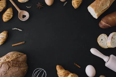 Elevated view breads utensils egg spices forming frame black background 스톡 사진